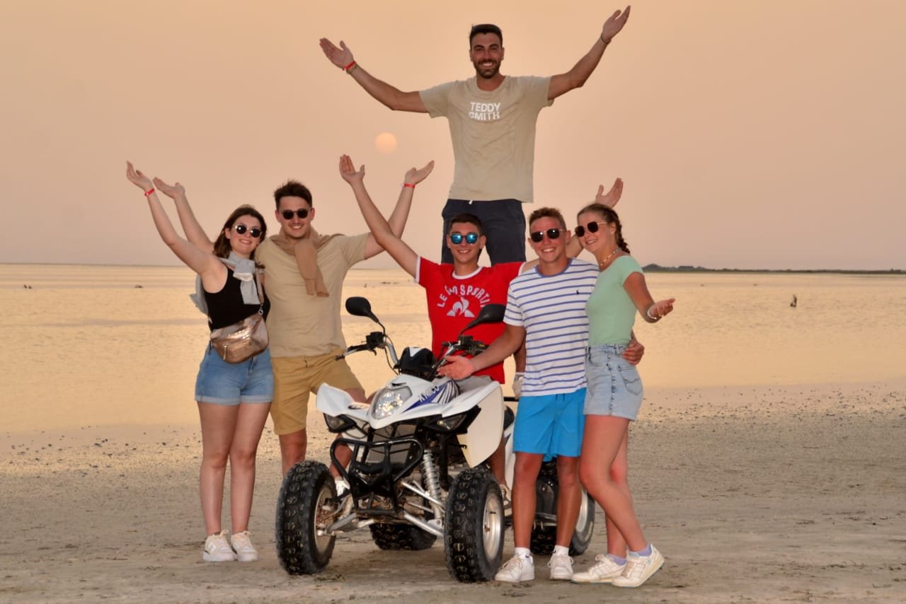 Quad rider on scenic trail through palm groves